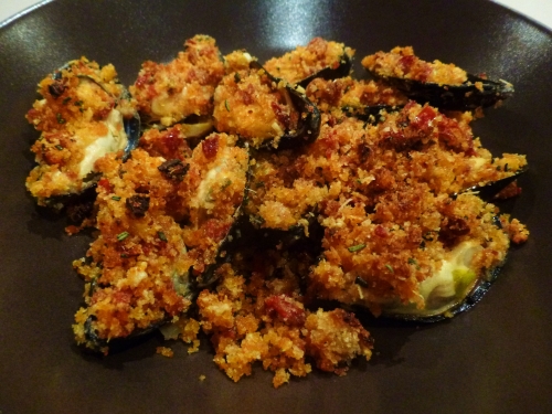 moules,céleri vert,oignon,vin blanc,thym,laurier,romarin,tomates sèchées,jambon de bayonne,ail,chapelure,huile d'olive,parmesan,concentré de tomates