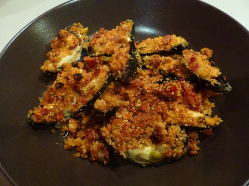 moules,céleri vert,oignon,vin blanc,thym,laurier,romarin,tomates sèchées,jambon de bayonne,ail,chapelure,huile d'olive,parmesan,concentré de tomates