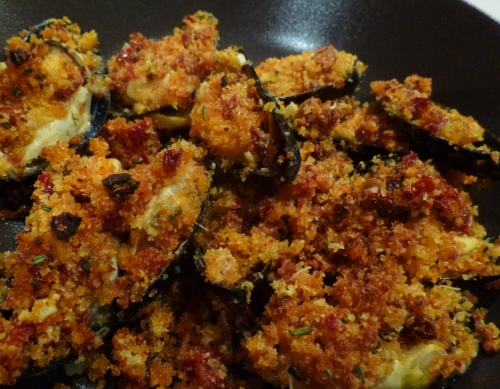 moules,céleri vert,oignon,vin blanc,thym,laurier,romarin,tomates sèchées,jambon de bayonne,ail,chapelure,huile d'olive,parmesan,concentré de tomates