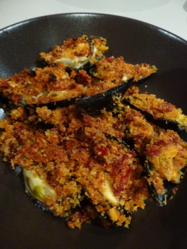 moules,céleri vert,oignon,vin blanc,thym,laurier,romarin,tomates sèchées,jambon de bayonne,ail,chapelure,huile d'olive,parmesan,concentré de tomates